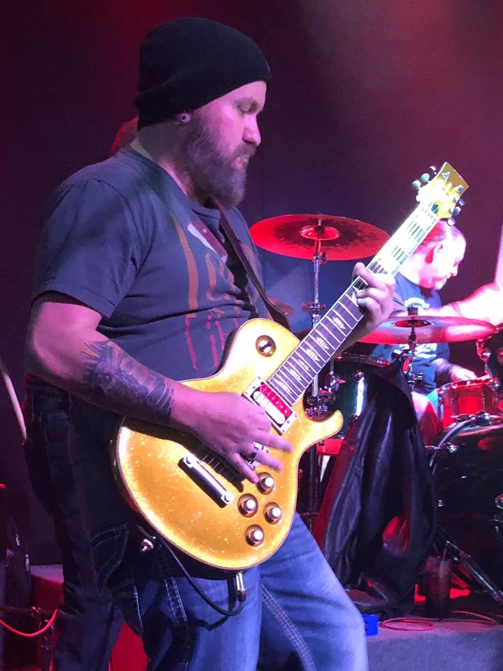 Corey Noles playing guitar on stage.